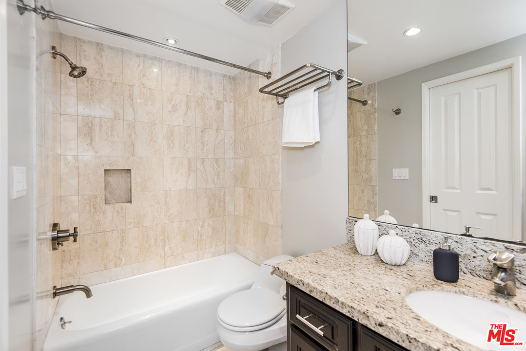 3612 Surfwood Road Malibu, CA 90265 - Photo 14 of 19 a bathroom with a granite countertop sink mirror toilet and bathtub