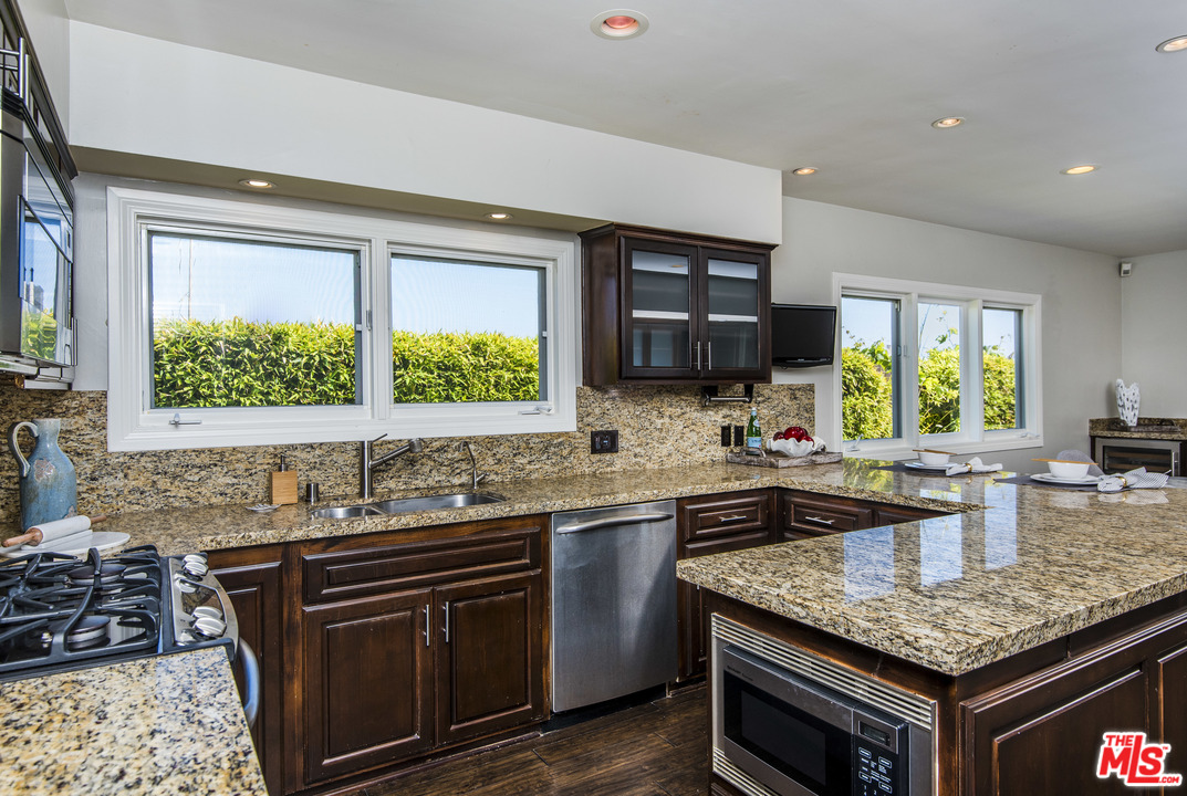 3612 Surfwood Road Malibu, CA 90265 - Photo 9 of 19 a kitchen with stainless steel appliances granite countertop a sink stove and cabinets