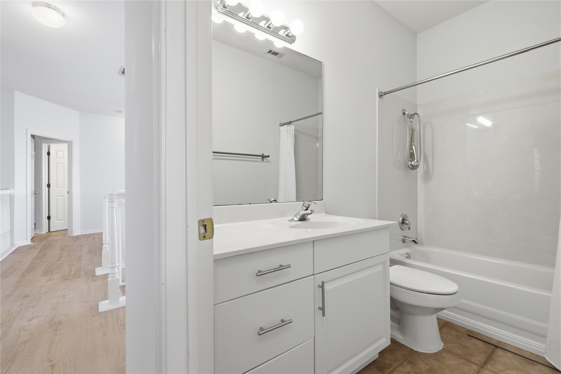 8204 Texas Plume Road Austin, TX 78759 - Photo 32 of 40 A well-appointed bathroom features a crisp white vanity and a practical tub-shower combination.