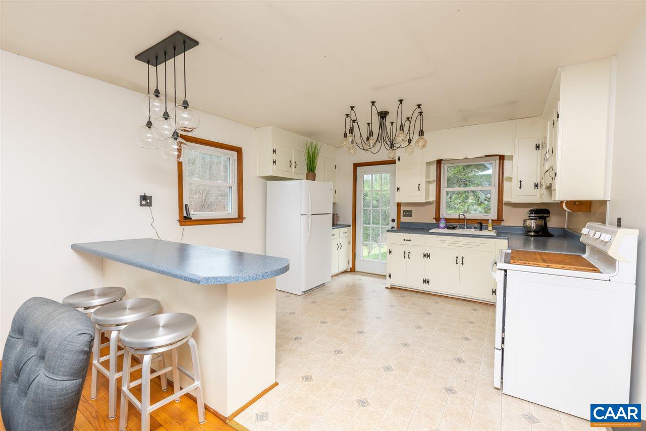 2564 Stagebridge Road Lovingston, VA 22949 - Photo 19 of 47 a view of a kitchen with granite countertop cabinets a sink and a wooden floor