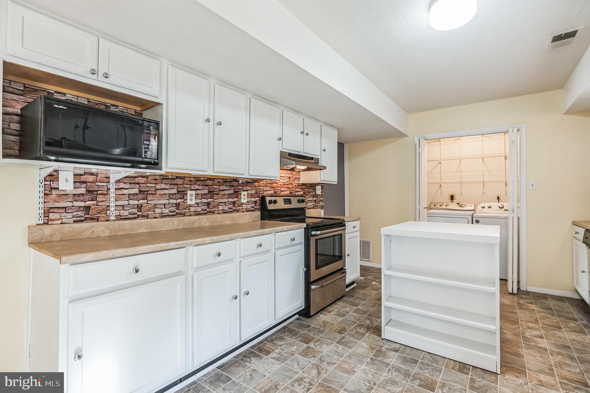 526 Maple Way Lusby, MD 20657 - Photo 8 of 26 a kitchen with stainless steel appliances white cabinets and a sink