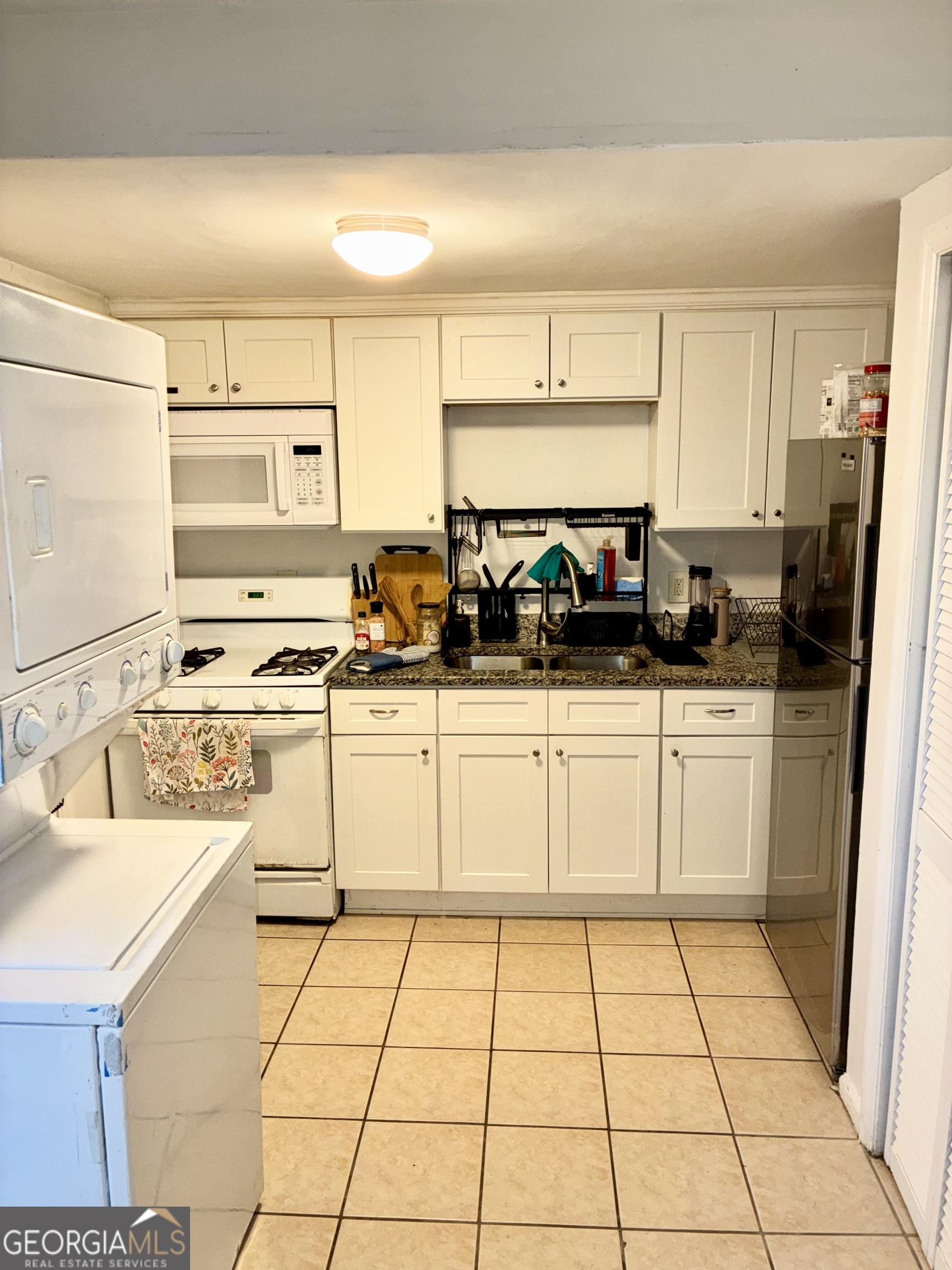 1859 Williams Avenue East Point, GA 30344 - Photo 6 of 20 a kitchen with a sink a stove top oven and white cabinets
