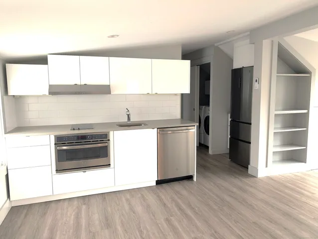 a kitchen with a refrigerator and a stove top oven