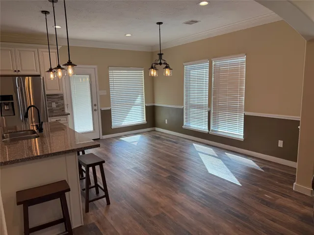 a view of a room with wooden floor stairs and a chandelier