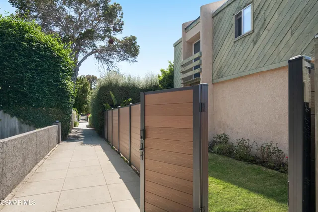 a view of a pathway of a house with wooden fence