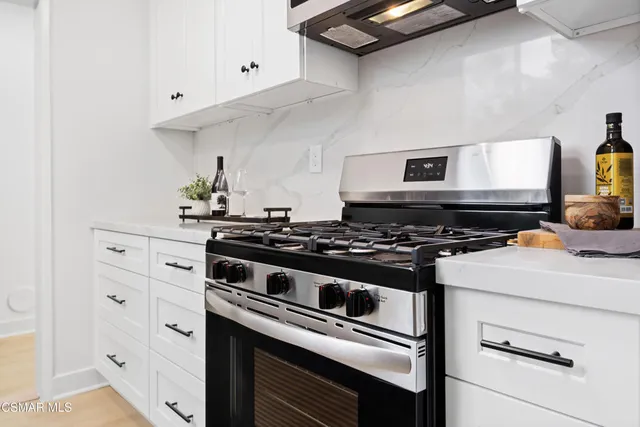 a stove top oven sitting inside of a kitchen