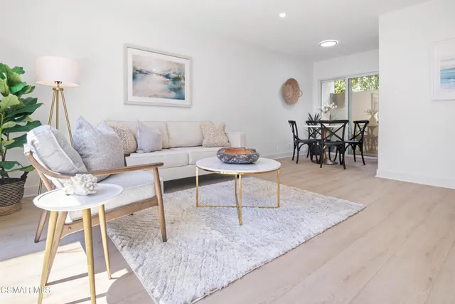 a living room with furniture and a painting on the wall
