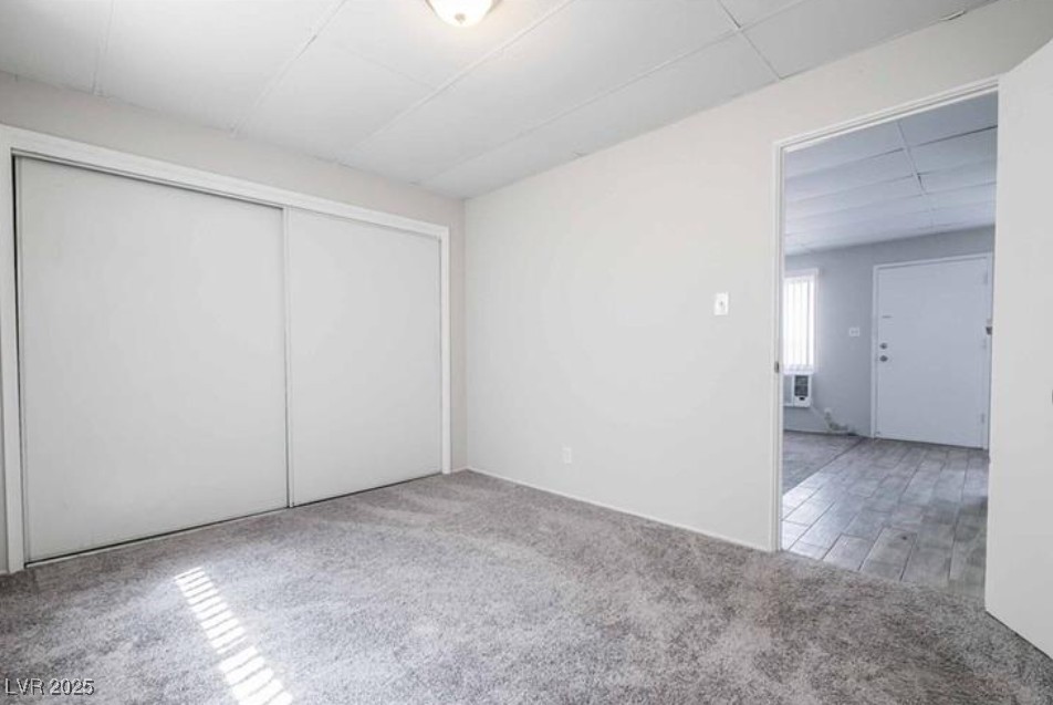 239 West Cleveland Avenue, Unit 1 Las Vegas, NV 89102 - Photo 11 of 12 Unfurnished bedroom with light colored carpet, a closet, and a drop ceiling