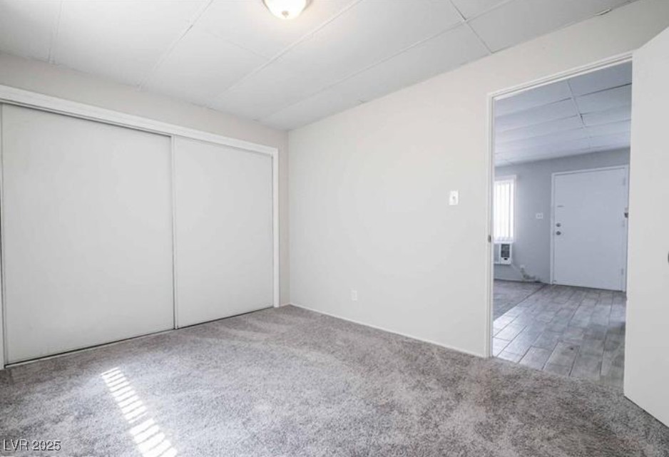 239 West Cleveland Avenue, Unit 1 Las Vegas, NV 89102 - Photo 8 of 12 Unfurnished bedroom with light colored carpet, a closet, and a drop ceiling