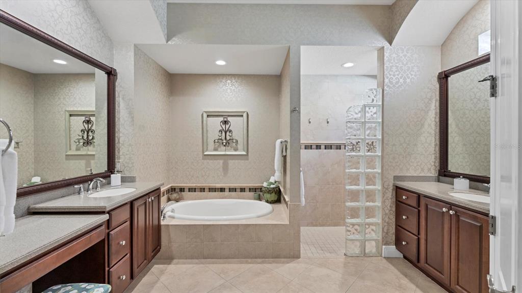 7833 Valderrama Way Lakewood Ranch, FL 34202 - Photo 22 of 63 a spacious bathroom with a double vanity sink a mirror a bathtub and shower