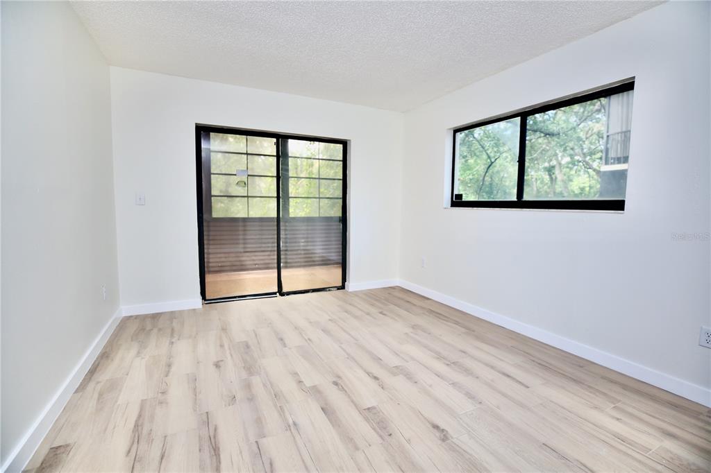 11702 Raintree Village Boulevard, Unit B Temple Terrace, FL 33617 - Photo 15 of 38 a view of an empty room with wooden floor and a window