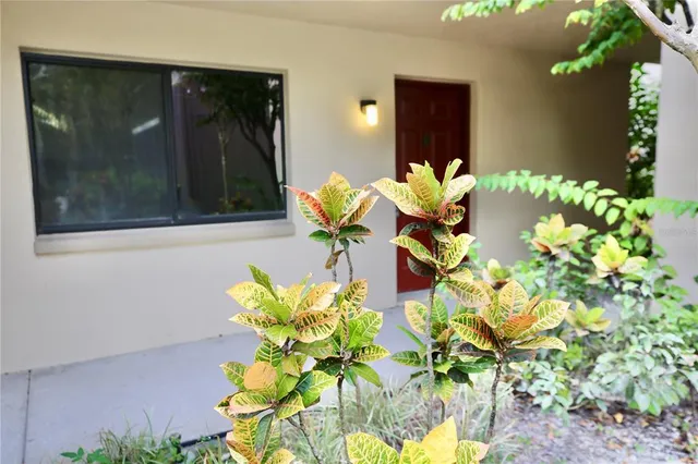a vase of flowers with a white house