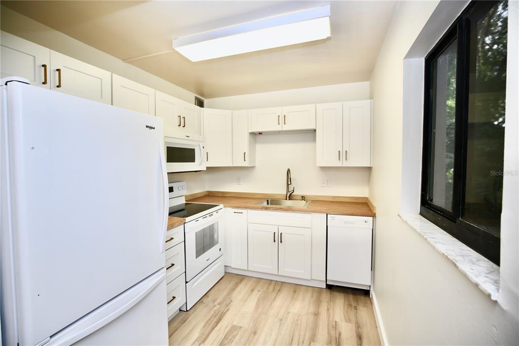 11702 Raintree Village Boulevard, Unit B Temple Terrace, FL 33617 - Photo 5 of 38 a kitchen with stainless steel appliances a sink a stove a refrigerator and cabinets