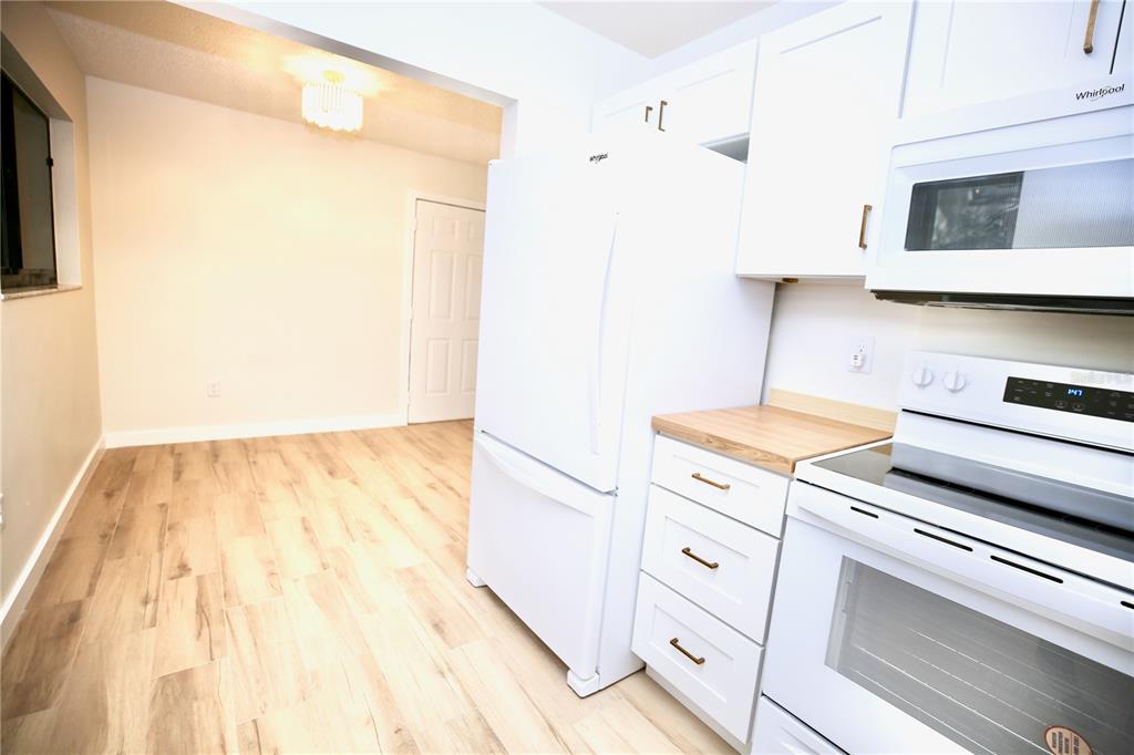 11702 Raintree Village Boulevard, Unit B Temple Terrace, FL 33617 - Photo 8 of 38 a kitchen with a stove and a white cabinet