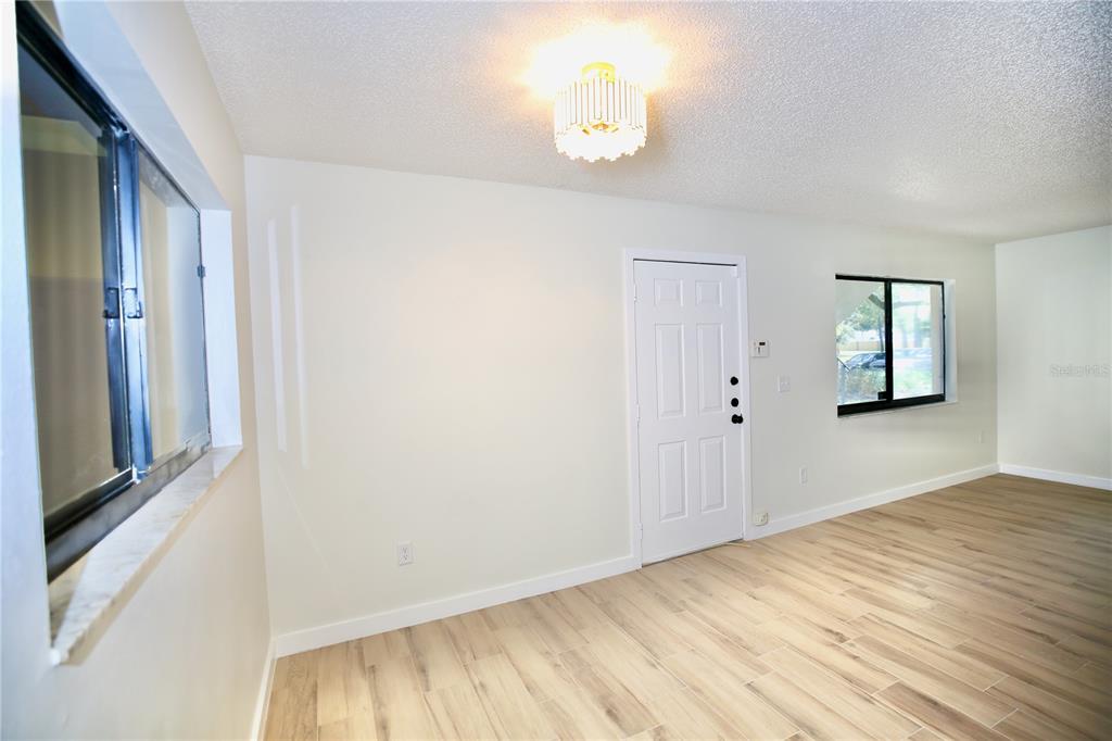 11702 Raintree Village Boulevard, Unit B Temple Terrace, FL 33617 - Photo 9 of 38 a view of empty room with wooden floor and fan