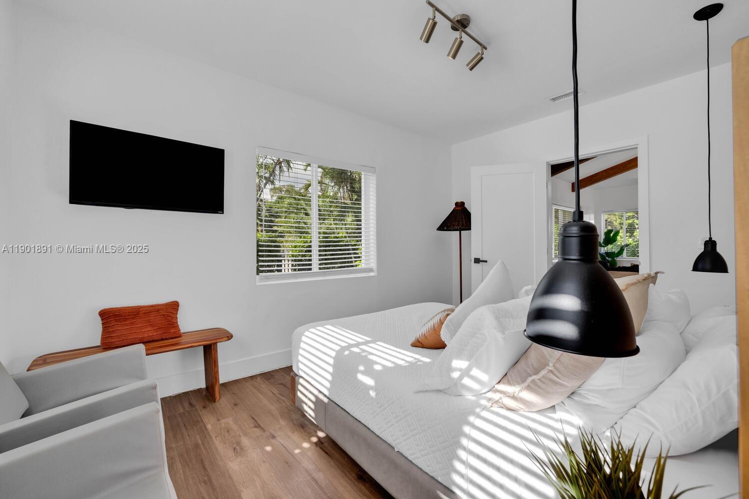 901 Northwest 7th Street Miami, FL 33136 - Photo 23 of 98 a bedroom with a bed a couch and a flat screen tv