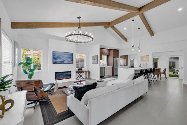 a large kitchen with stainless steel appliances a refrigerator a stove a sink dishwasher a oven with white cabinets and wooden floor