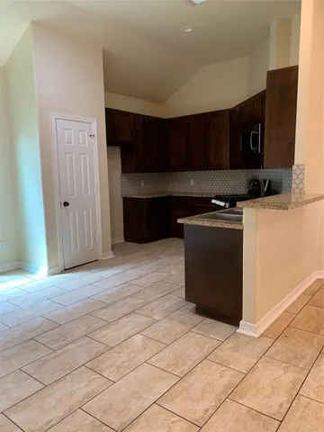 a kitchen with stainless steel appliances granite countertop a refrigerator and a stove
