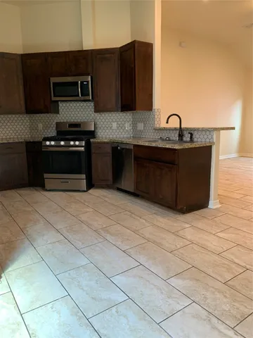a kitchen with stainless steel appliances granite countertop a sink and a stove