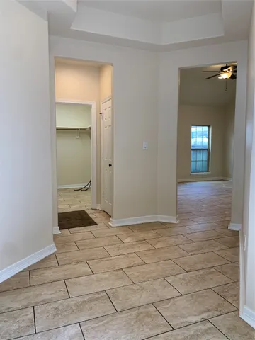 a view of a hallway with wooden floor and a bathroom