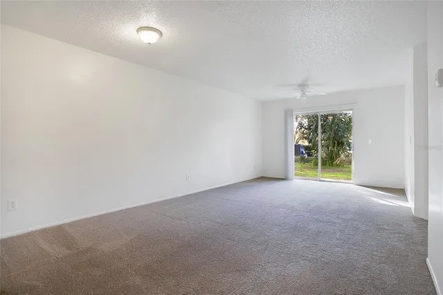 a view of a big room with windows and chandelier fan