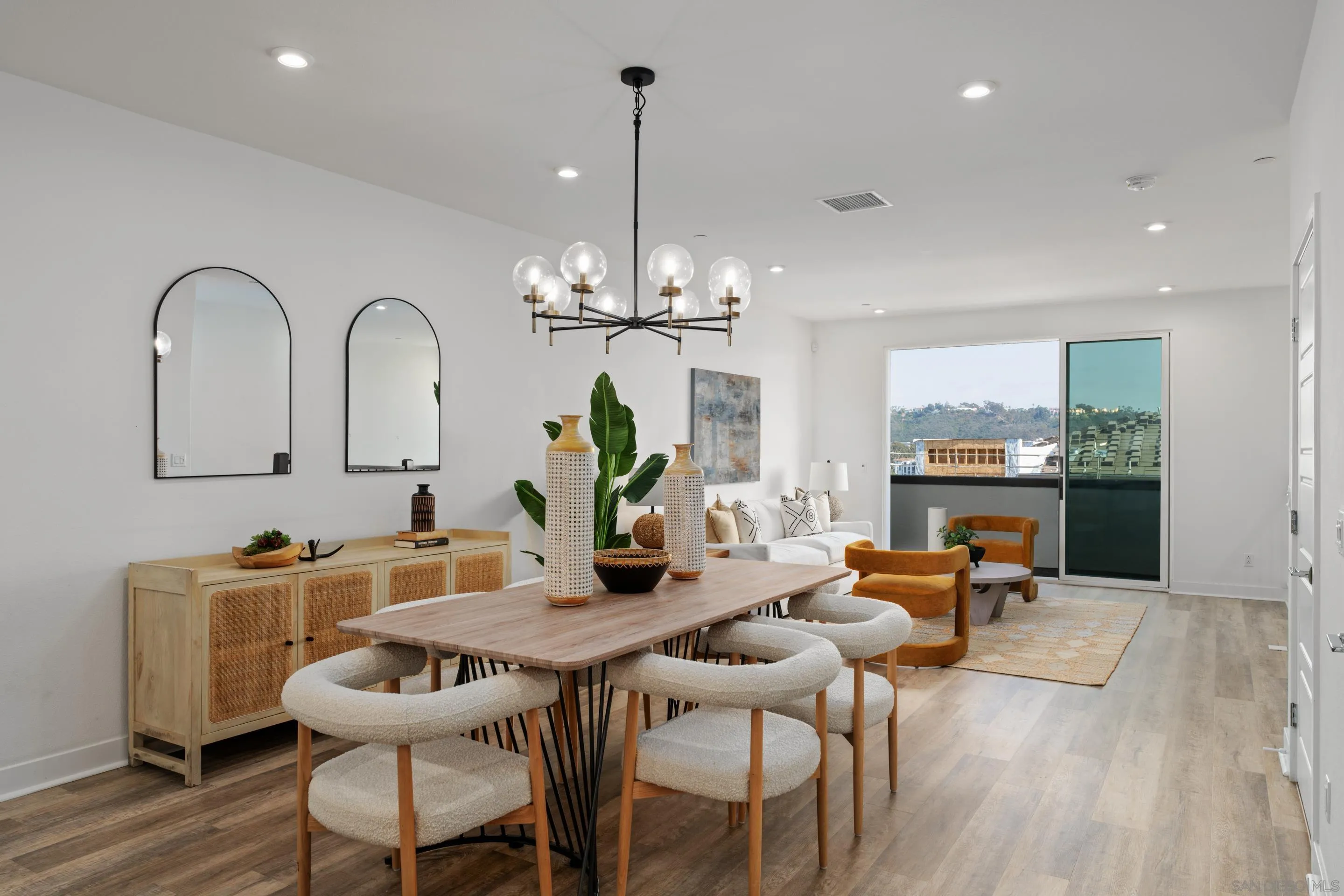 a dining room with furniture a chandelier and wooden floor