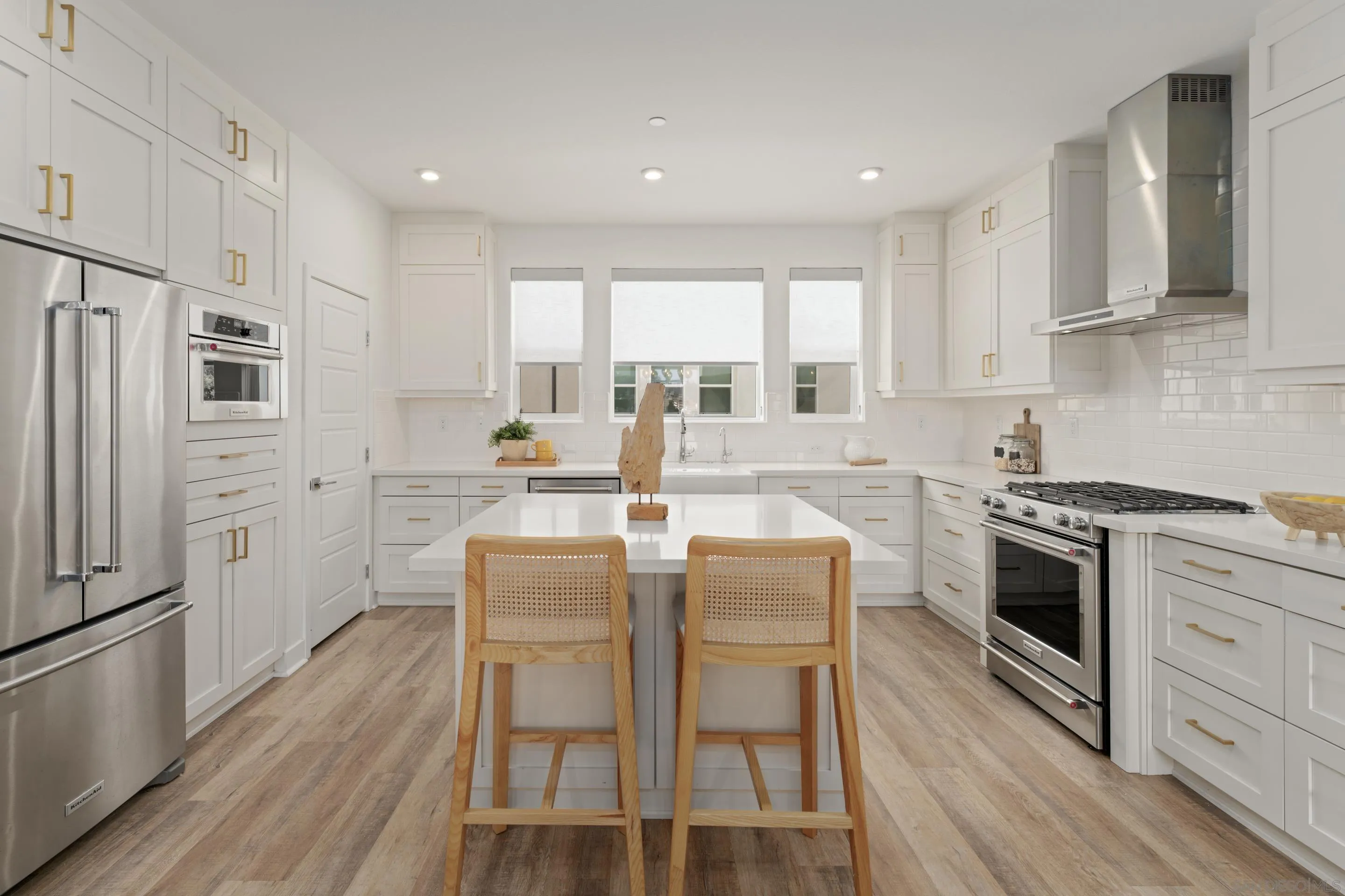 2731 Via Avella San Diego, CA 92108 - Photo 3 of 39 a kitchen with stainless steel appliances granite countertop a stove top oven a sink dishwasher a refrigerator and white cabinets with wooden floor