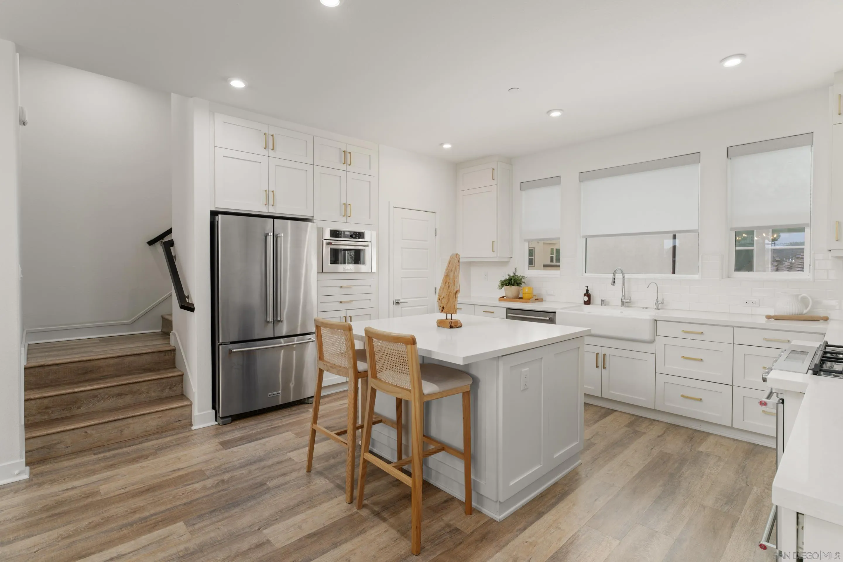 2731 Via Avella San Diego, CA 92108 - Photo 6 of 39 a kitchen with a sink a refrigerator and white cabinets