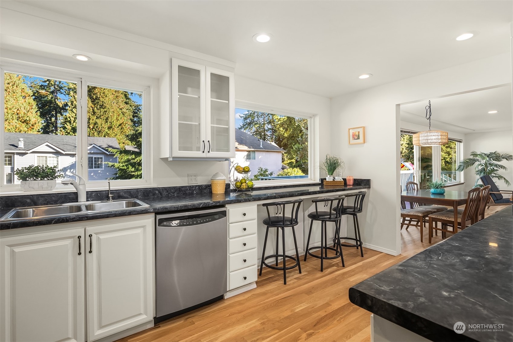 1834 North 183rd Street Shoreline, WA 98133 - Photo 15 of 40 a kitchen with stainless steel appliances granite countertop a stove a sink a microwave dining table and chairs