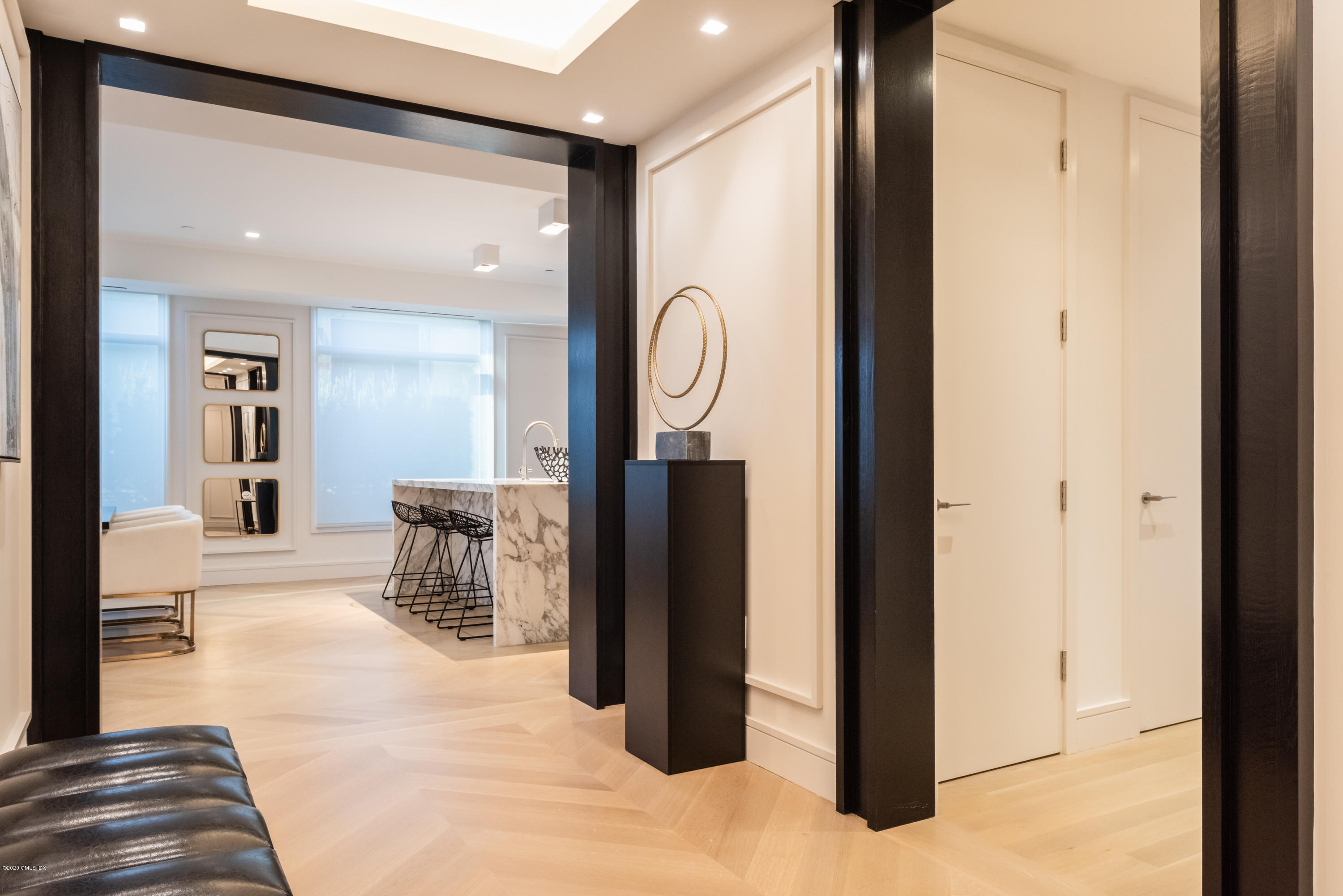 a view of a hallway with wooden floor windows and a living room