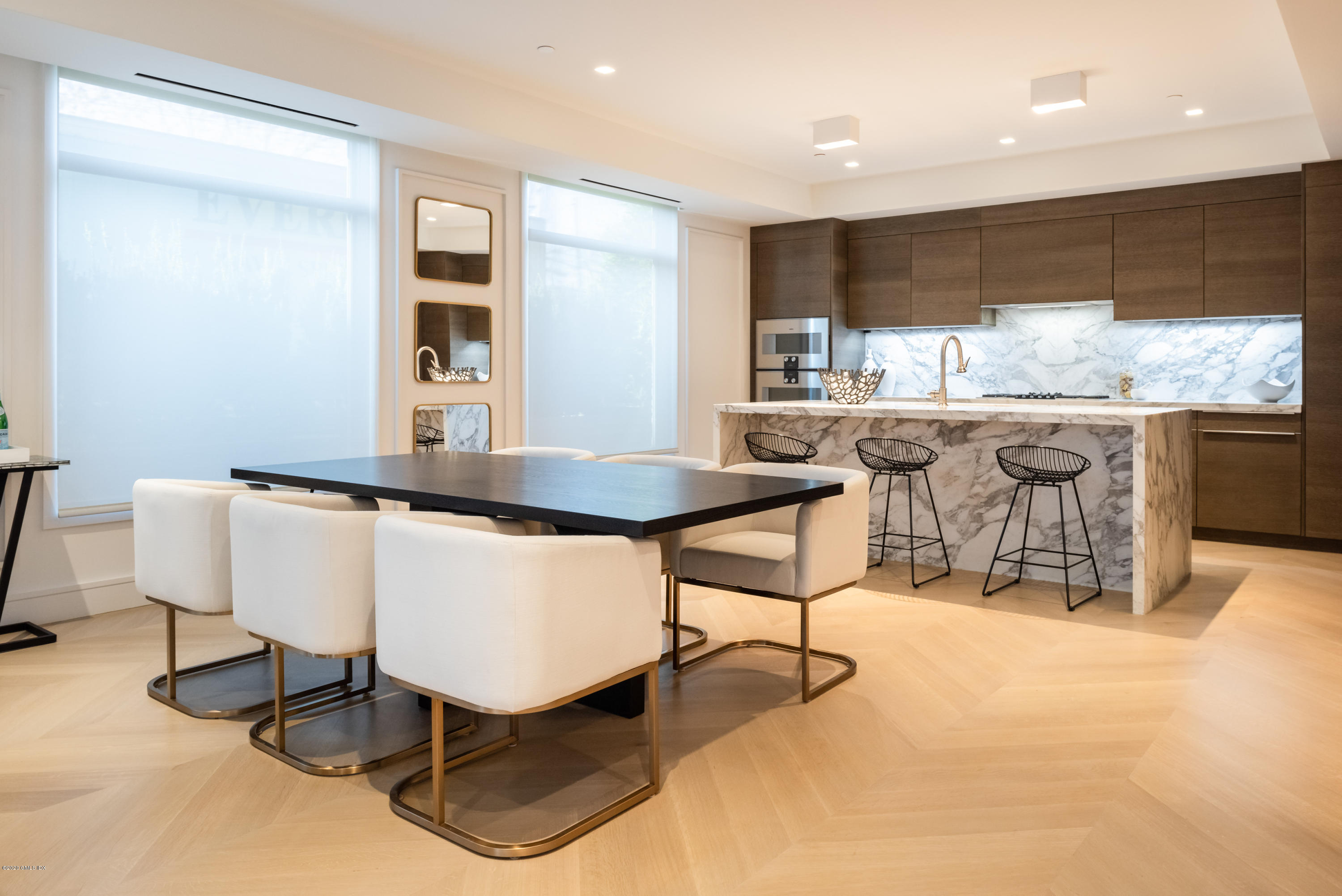 125 Field Point Road, Unit 1A Greenwich, CT 06830 - Photo 4 of 25 a living room with kitchen island furniture a rug and white walls
