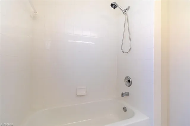 a bathroom with a bath tub with a shower