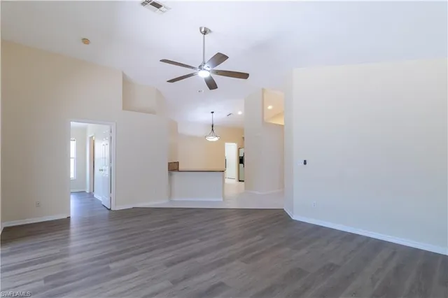 a view of empty room with wooden floor and ceiling fan