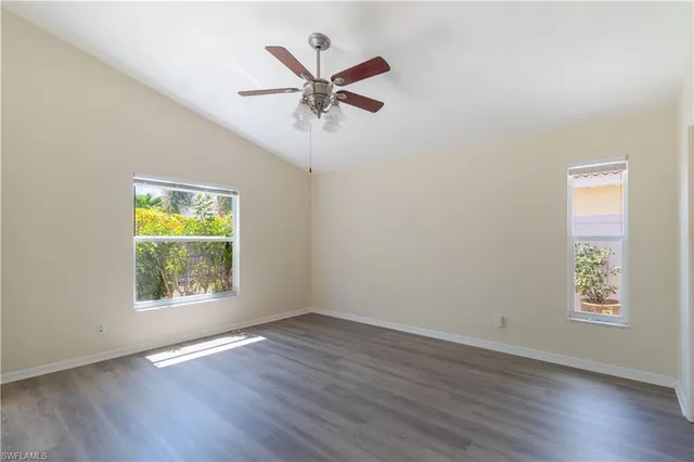 a view of a big room with wooden floor and windows