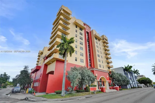 a view of a tall building next to a yard