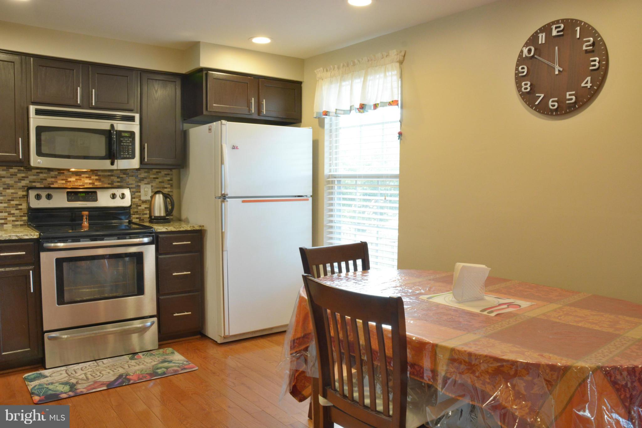 45322 Gable Square Sterling, VA 20164 - Photo 11 of 30 a kitchen with stainless steel appliances granite countertop a refrigerator a stove a sink and a microwave