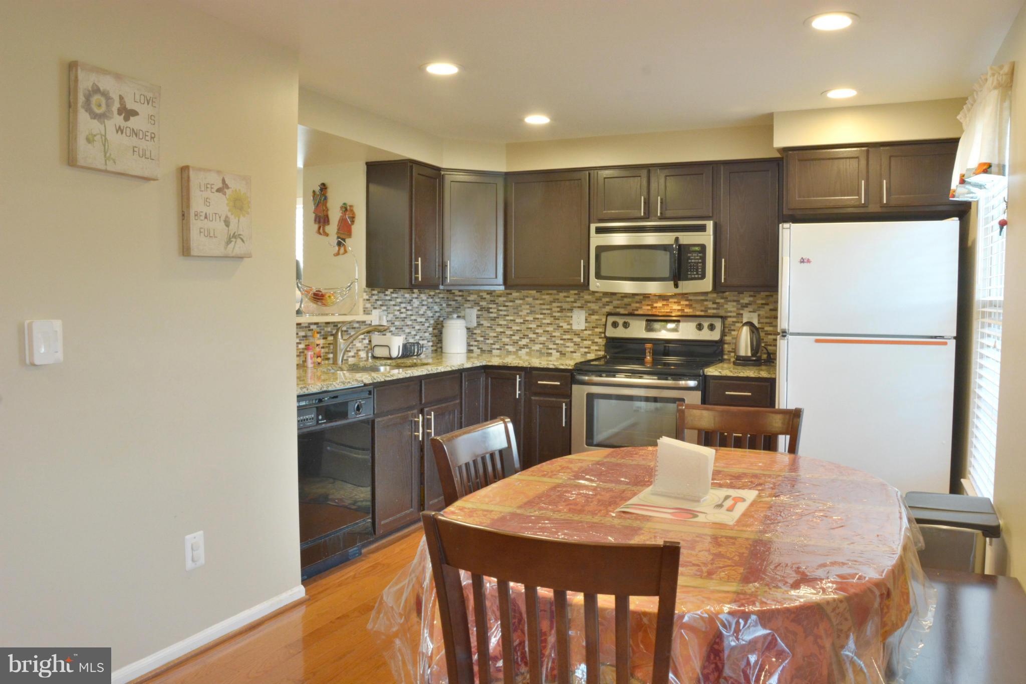 45322 Gable Square Sterling, VA 20164 - Photo 10 of 30 a kitchen with kitchen island a counter top space cabinets and stainless steel appliances