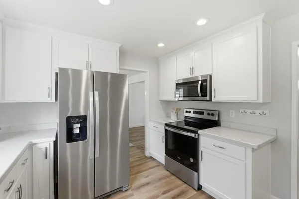 a kitchen with stainless steel appliances a refrigerator a stove top oven a sink and dishwasher