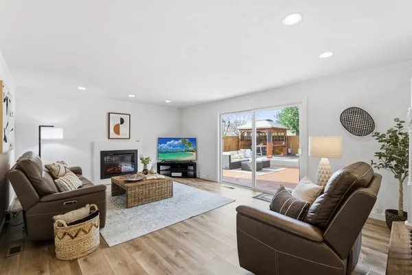 a living room with furniture a fireplace and a floor to ceiling window