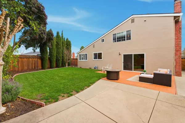 a view of a house with backyard and a tree
