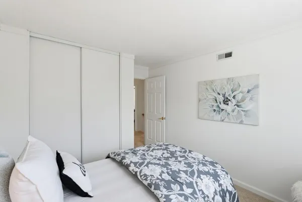 a bedroom with a bed and a painting on the wall