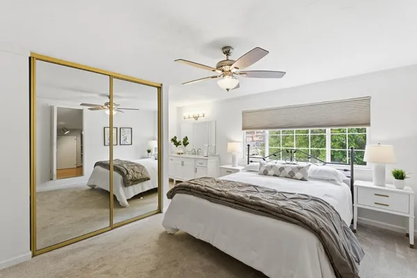 a spacious bedroom with a bed and a chandelier