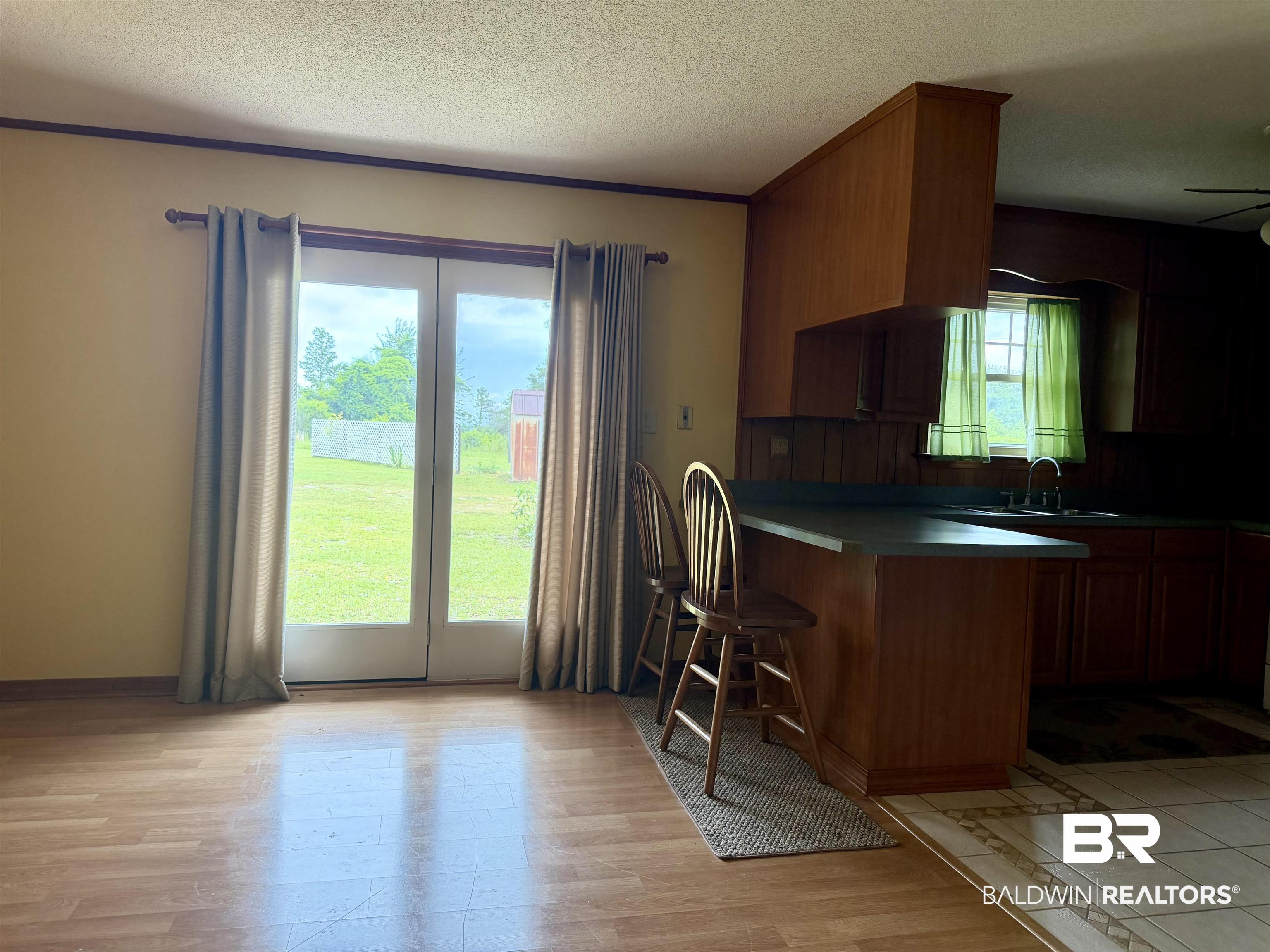 3642 Old Castleberry Road Brewton, AL 36426 - Photo 6 of 14 Wood-finish flooring throughout, complemented by a kitchen bar with a dark countertop