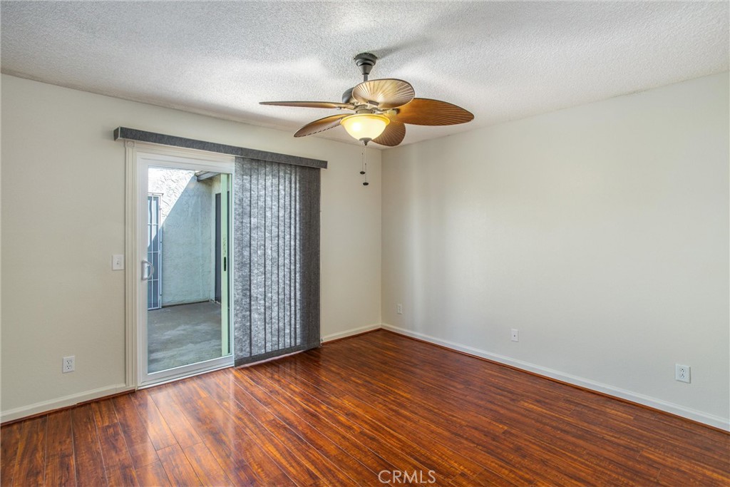 29252 Murrieta Road Menifee, CA 92586 - Photo 14 of 28 a view of an empty room with wooden floor and a ceiling fan