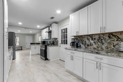 a kitchen with white cabinets and stainless steel appliances