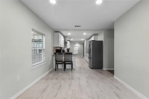 a view of kitchen with refrigerator and windows