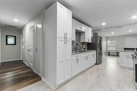 a kitchen with white cabinets and stainless steel appliances