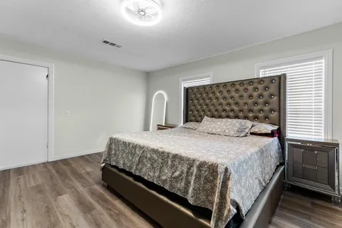 a bedroom with a bed and wooden floor