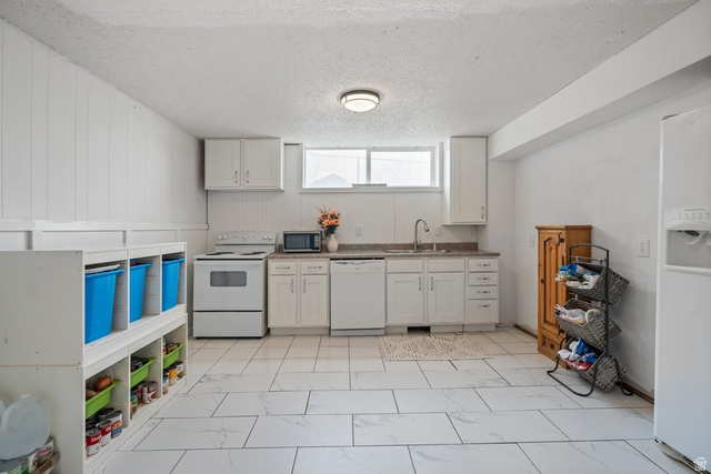 149 West 1600th Street South Mapleton, UT 84664 - Photo 33 of 44 Kitchen featuring white appliances, a textured ceiling, white cabinetry, and light marble finish floors