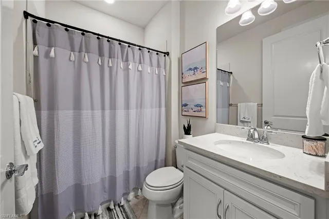a bathroom with a granite countertop sink toilet and a mirror